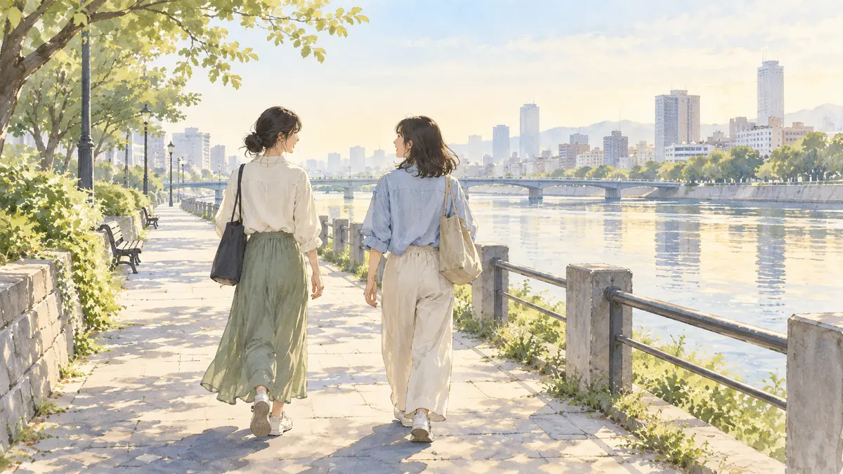 川沿いの道を並んで歩く二人の女性