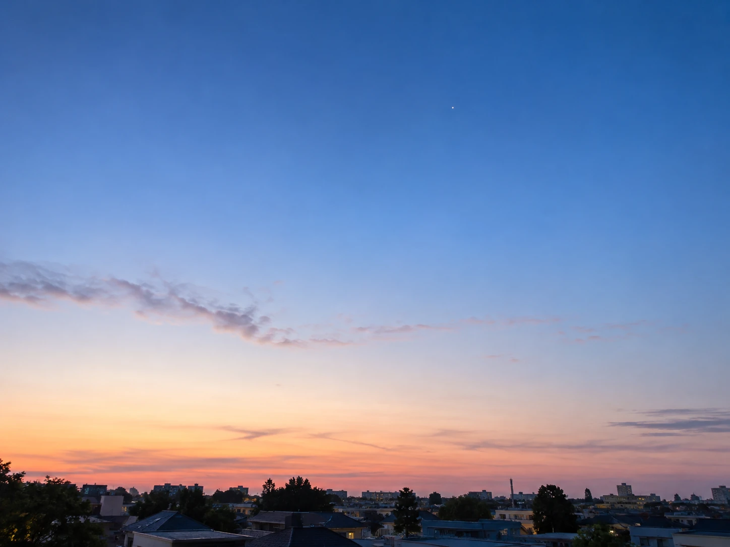夜明けの町並みの上に広がる空と、小さく残るひとつの星